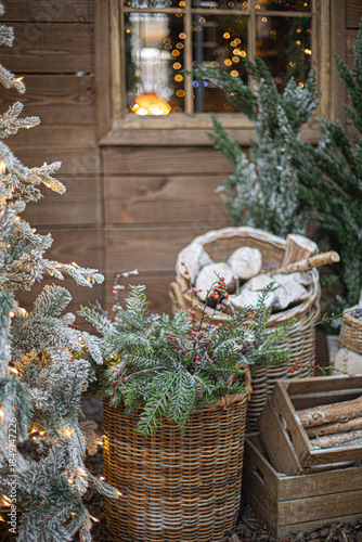 Christmas tree decorated with pine cones, basket with firewood