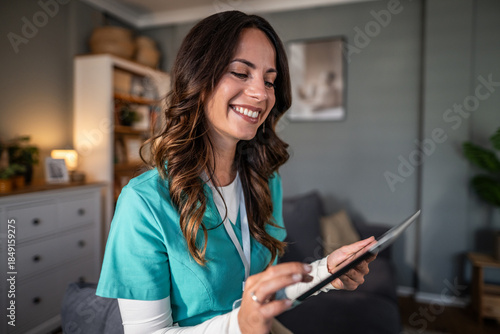Smiling home care nurse using digital tablet