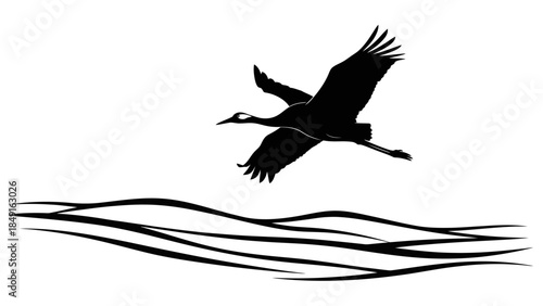 Silhouette of a flying heron over rippling water waves in a minimalistic black and white