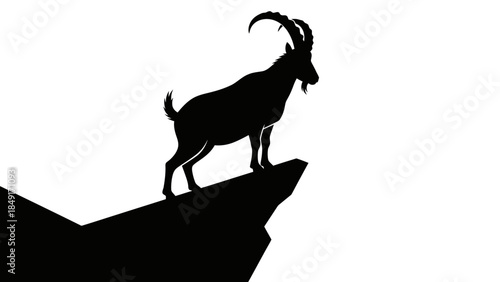 Silhouette of a majestic mountain goat standing proudly on a rugged cliff edge