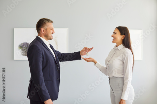 Foto Real estate agent or realtor hands over keys to a happy client after the successful purchase or rent of a new home