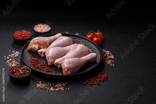 Bild auf Leinwand Chicken meat, raw drumsticks on the bone for grilling with salt and spices