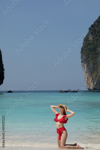 young woman in a red swimsuit on the Maya Bay beach and sunglasses