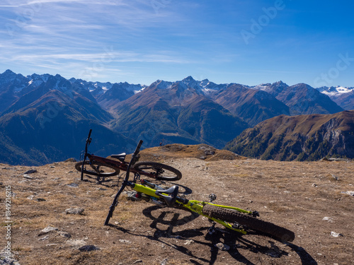 Scuol, Switzerland - October 11th 2025: Two bikes in front of the impressive view from motta naluns biking resort