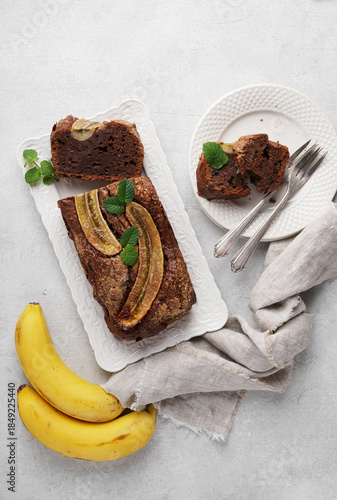 Homemade banana bread with dark chocolate close-up on table. Vertical top view