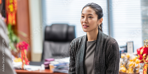 A asian female professional dialogue within a modern office setting. She exudes confidence and poise, demonstrating active listening skills.
