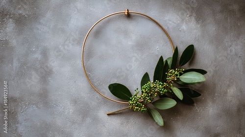 Fototapeta Naklejka Na Ścianę i Meble -  Minimal wall wreath made of thin gold hoop and small greenery cluster