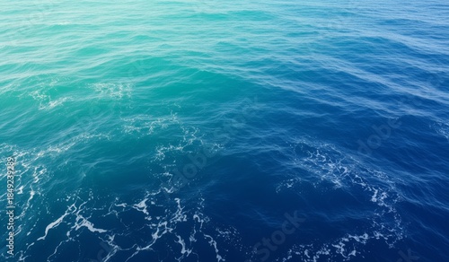 Calm azure waves gently ripple under a warm sun in vast ocean space