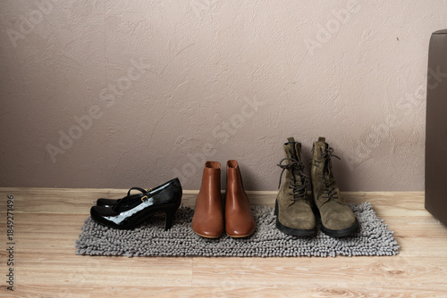 Shoes neatly arranged on rug near wall in home interior