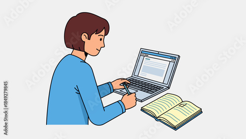A person with brown hair and a blue shirt is sitting at a desk, typing on a silver laptop computer while an open book lies beside it, suggesting study or work.