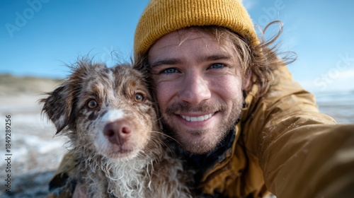A joyful young man enjoys a beach day with his playful dog, capturing happiness and companionship in a bright outdoor setting filled with waves and sunshine.