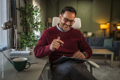 Man working remote from home office reviewing documents