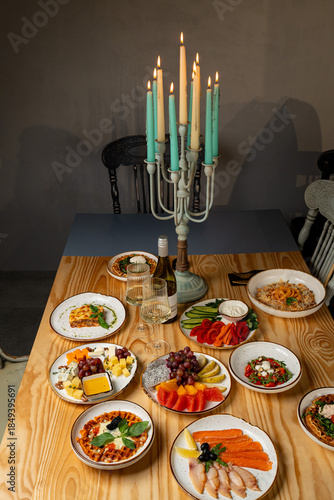 Canvas-taulu Guests gather around a wooden table adorned with elegant dishes, showcasing vibr