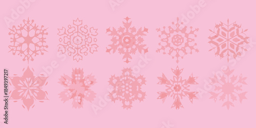 Delicate pink snowflakes arranged in a row on a soft pink background