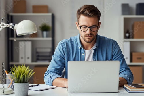 Focused businessman working on laptop in modern office