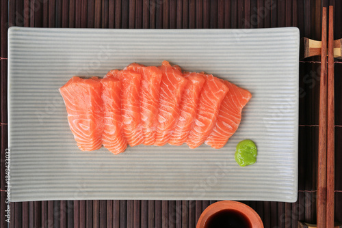 Salmon fillet japanese food, Fresh raw fish on plate against bamboo wooden mat background. Top view.