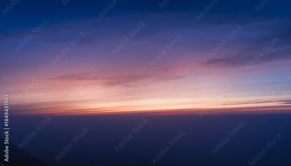 Fototapeta premium An abstract skyscape where soft gradients of blue, purple, and orange meet the horizon in a calm, cinematic moment of twilight