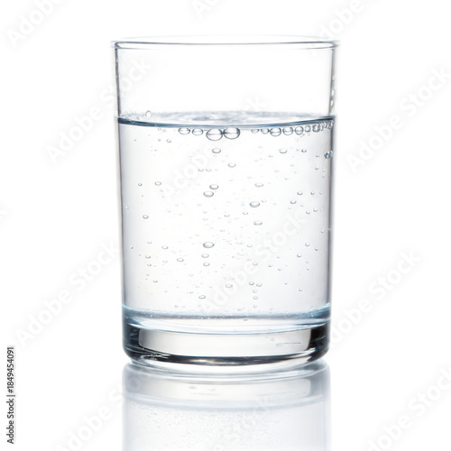 Clear glass filled with sparkling water showcases bubbles rising to surface against transparent background, creating refreshing visual