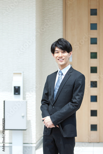 自宅の前に立つビジネスマン