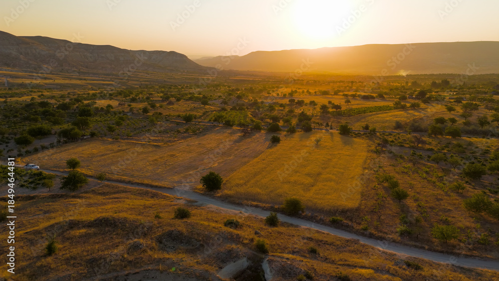 Obraz premium Goreme, Nevsehir, Turkey. Sun-drenched eroded plateau with intricate valley network and fairy chimneys in warm morning light over Cappadocia. Aerial View