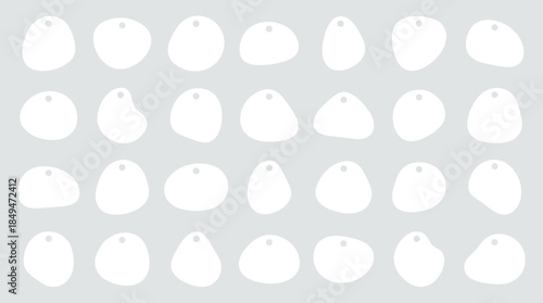 Collection of white stones or pebbles arranged in rows on a gray background viewed from directly above