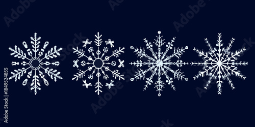 Four intricate white snowflakes displayed against a dark navy blue background