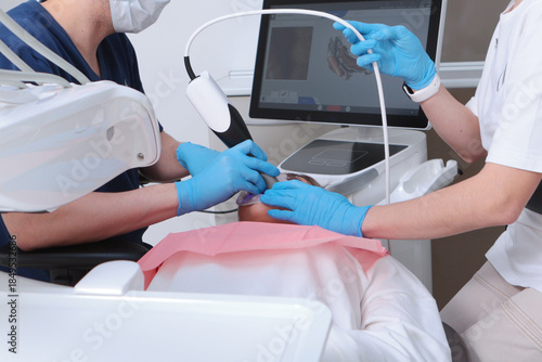 The process of digital dental scanning. The dentist examines the patient's teeth using a scanner. 3D dental scanning. Dental treatment. Horizontal.