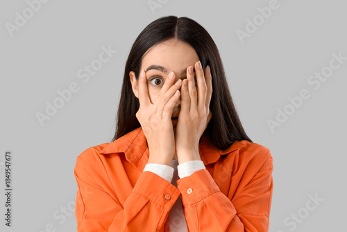Young woman peeking through...