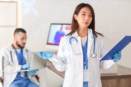 Female Asian doctor with clipboard analyzing scientific data in laboratory