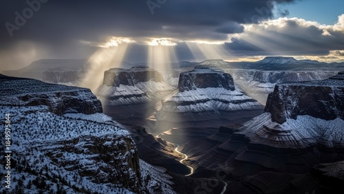 Dramatic Sunbeams Pierce Stormy Skies Over Snow-Dusted Grand Canyon Mesas.
