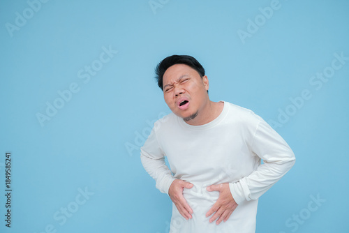 Slika na platnu a young asian man has stomach ache hand expression when having stomach ache with