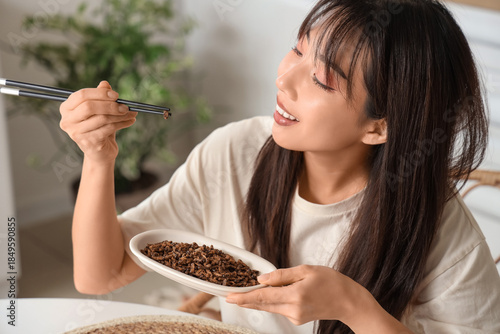 Young Asian woman eating fr...
