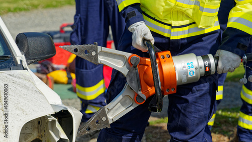 A firefighter pulls open a crashed car with a tool known as The Jaws Of Life