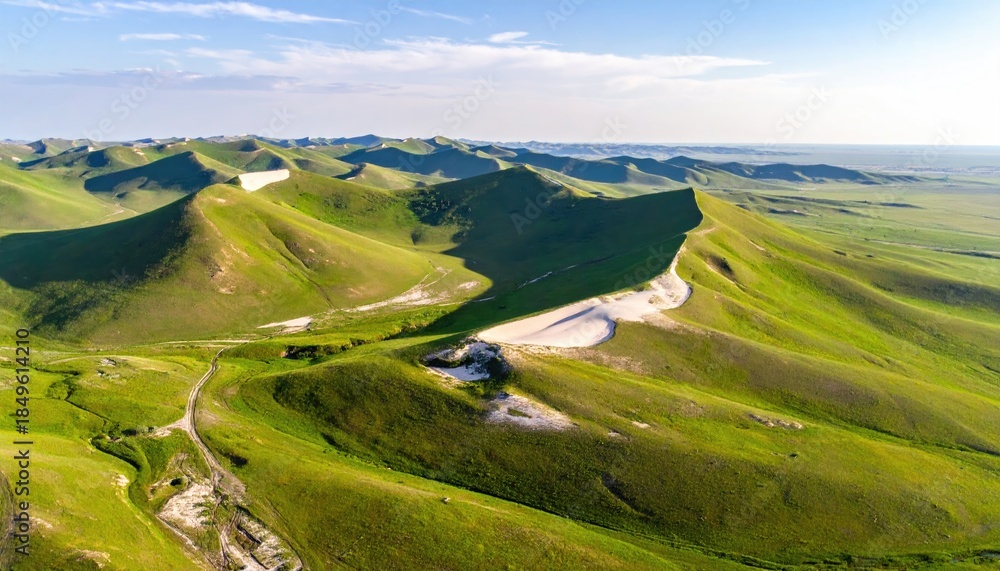 Naklejka premium Rolling green hills meeting a desert-like expanse under a bright sky