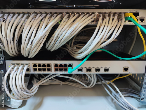 Close-up of Organized Network Switches and Patch Panels with White and Colored Ethernet Cables in a Corporate Data Center Server Rack