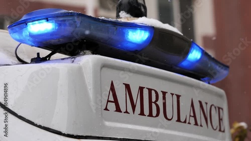 Ambulance with flashing blue lights on a snowy day, symbolizing urgent rescue in harsh weather.