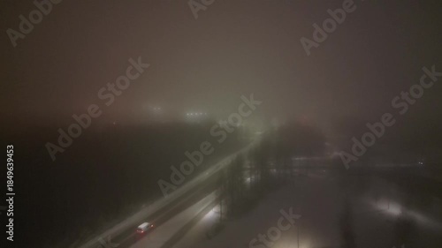 Aerial view of a car driving along foggy road