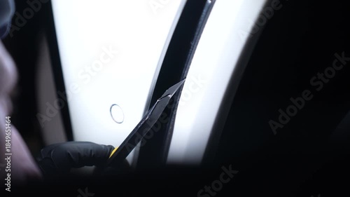 A technician removes protective film from a car. Auto detailing.