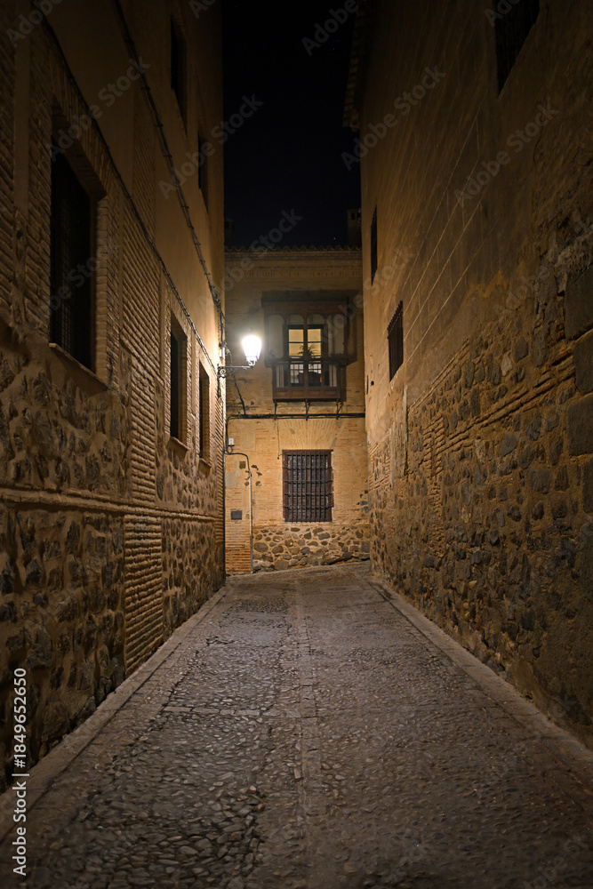 Fototapeta premium Cobbled alleyway lit in Toledo