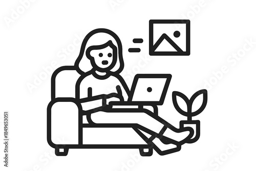 Woman working on laptop on a couch with plant and picture frame
