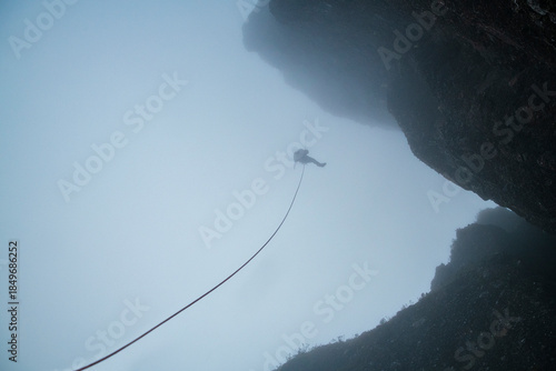 Rock Climber Hanging on Rope in a Minimal Mountain Landscape