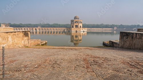 Scenic landscape view of ancient octagonal pavilion and brick causeway on mughal era Hiran Minar water tank pool, Sheikhupura, Punjab, Pakistan