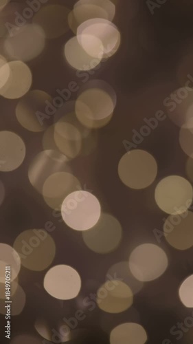 A blurred background of golden bokeh lights on a dark surface. The scene creates a warm and festive atmosphere, ideal for celebrations or holiday themes.
