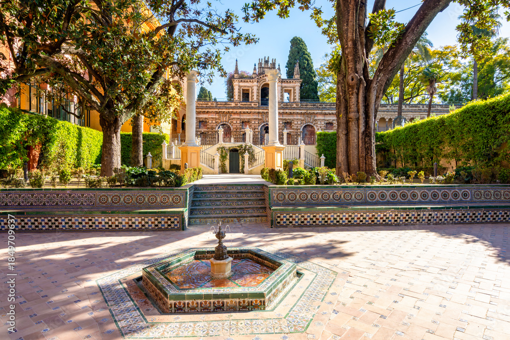 Fototapeta premium Courtyard with fountain in Alcazar of Seville gardens, Andalusia, Spain