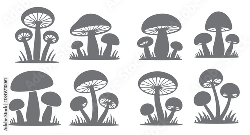 nine gray mushroom silhouette groups set in grass simple