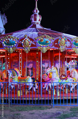 Foto A Merry go round illuminated with neon lights at an amusement park, fun fare, carnival, circle, excitement, theme park, attraction, Dussehra in India