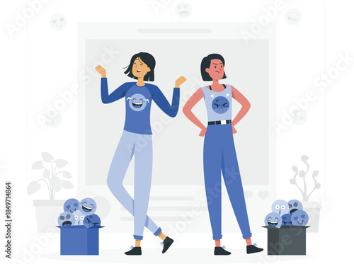 Two women standing with emotion faces on their shirts and boxes of emoticon faces blue shirts pants