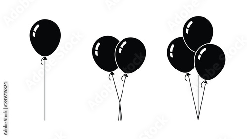 Black balloons floating in the air, a simple yet festive decoration for any celebration or event, viewed from a straightforward perspective.