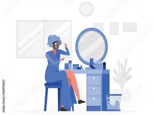 Woman in blue robe and towel on head applying face cream face mask applying cream des