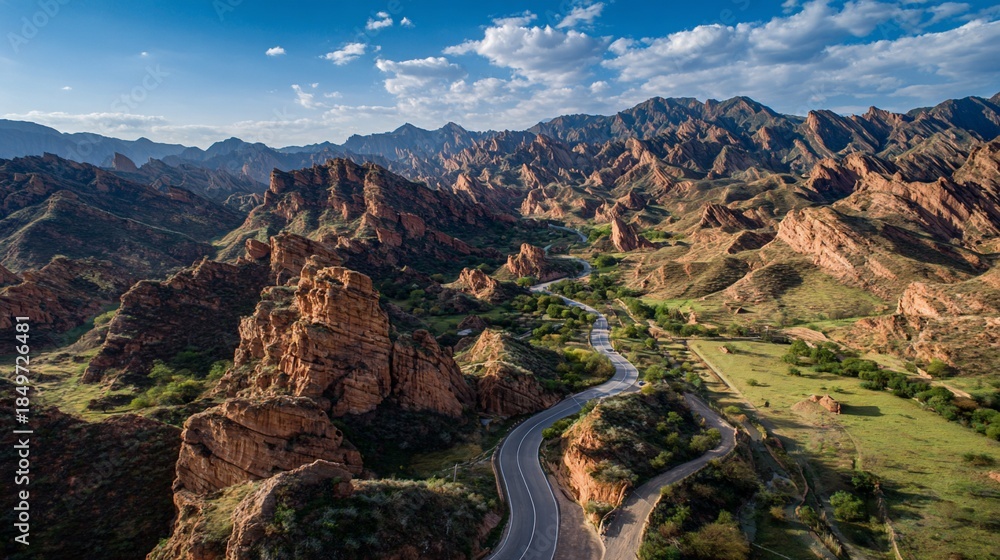 Naklejka premium Red rock canyon landscape with winding road and river under a blue sky